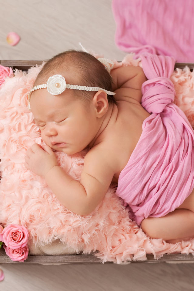 Спящий младенец с розовыми лепестками роз