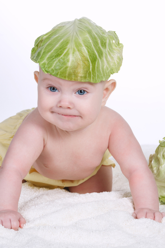 Маленький грудной ребенок с капустным листом на голове
