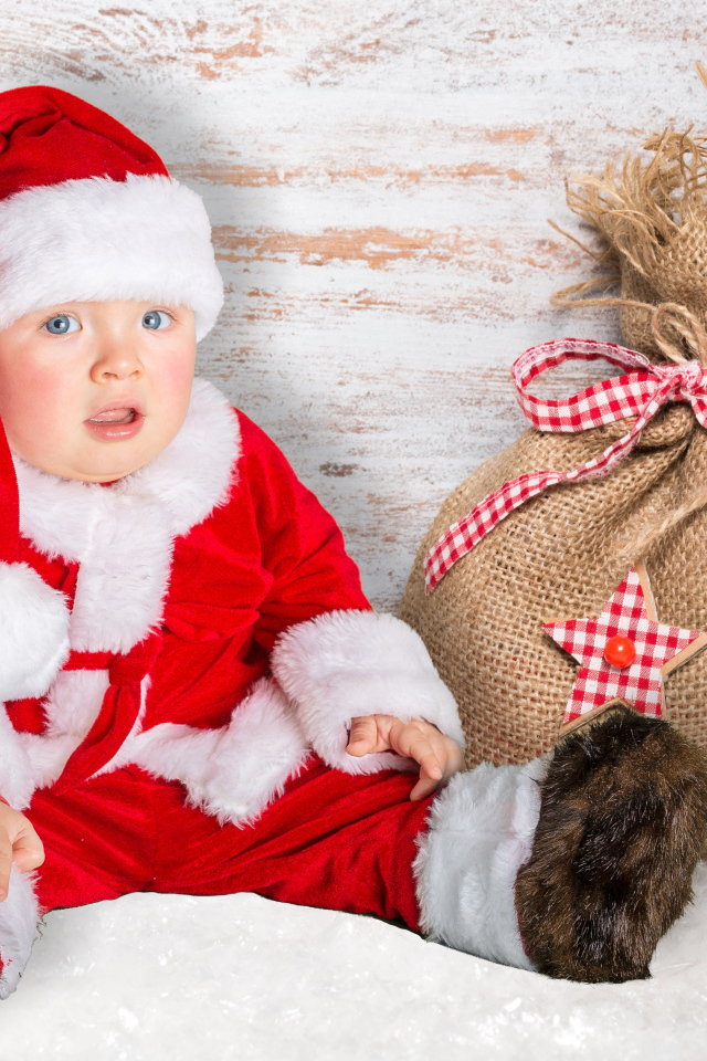 Маленький ребенок в костюме Санты с мешком