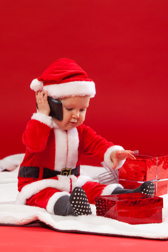 Маленький ребенок в новогодней униформе с подарками