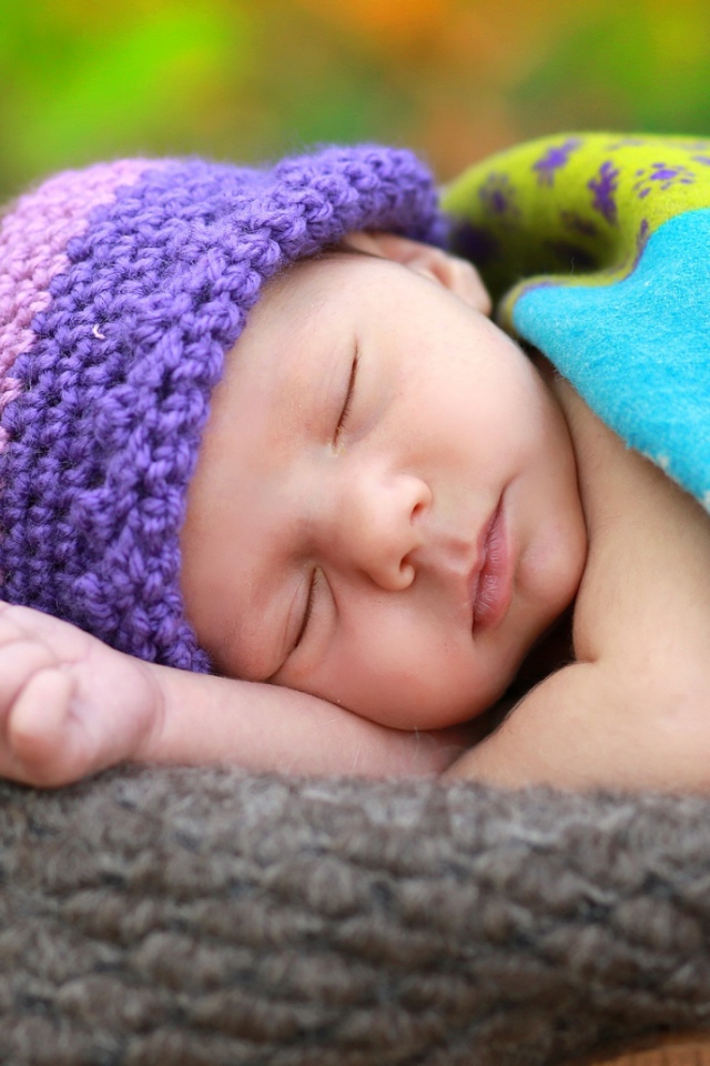 Маленький спящий младенец в вязаной шапке 
