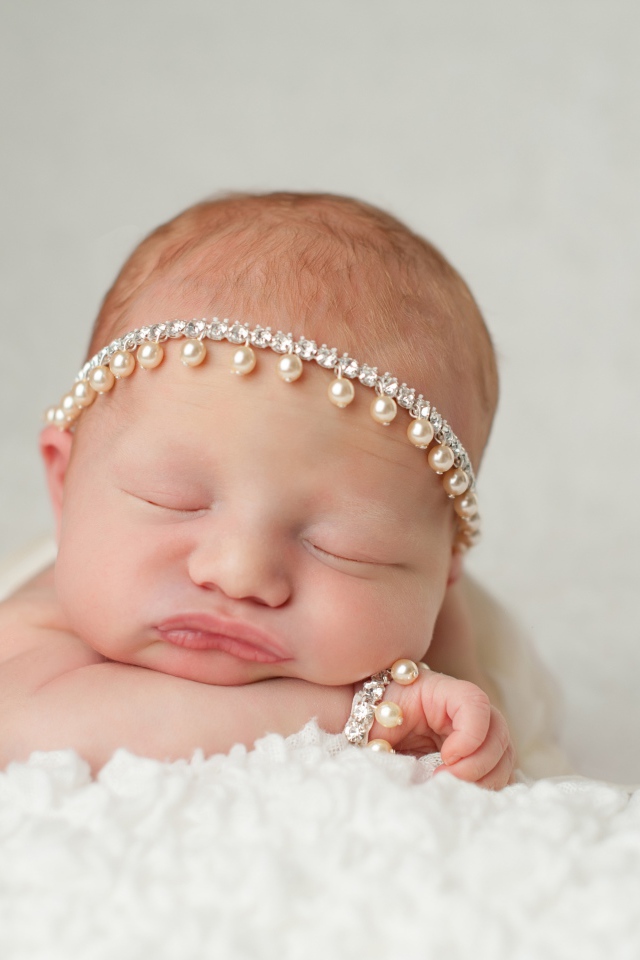 Маленький спящий грудной ребенок с красивым украшением на голове