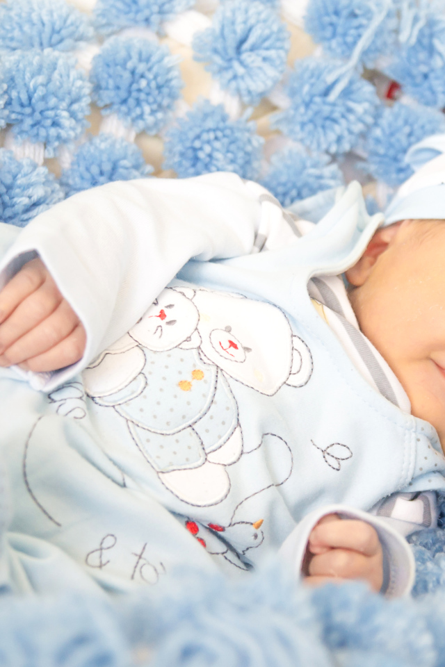 Младенец мальчик улыбается во сне