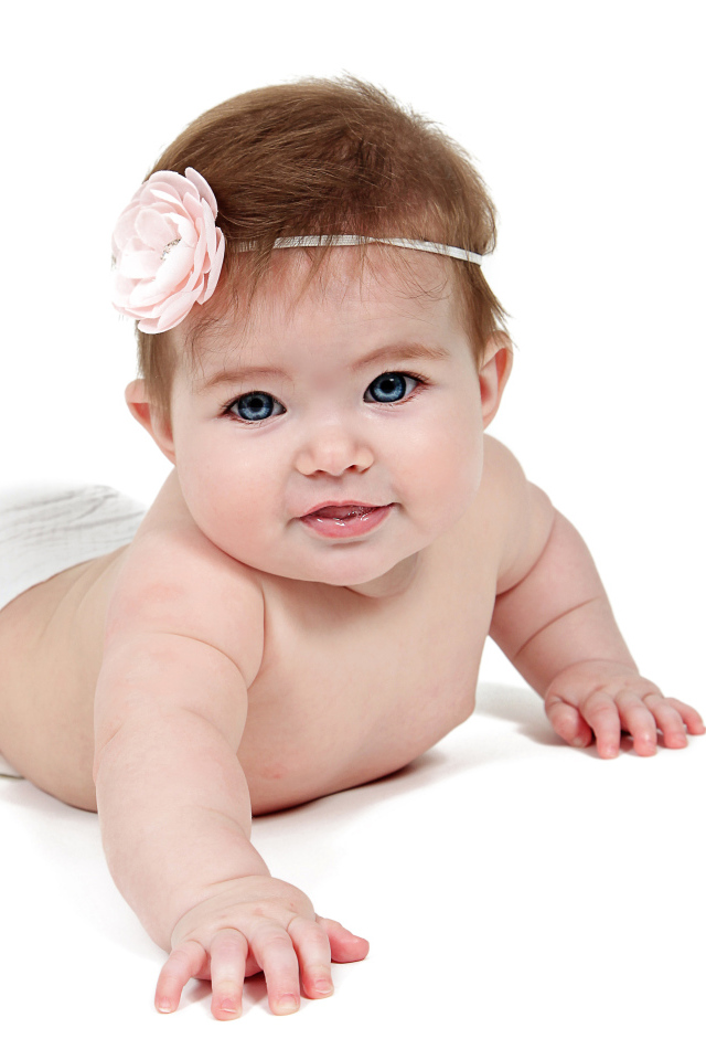 Младенец девочка с цветком на голове на белом фоне