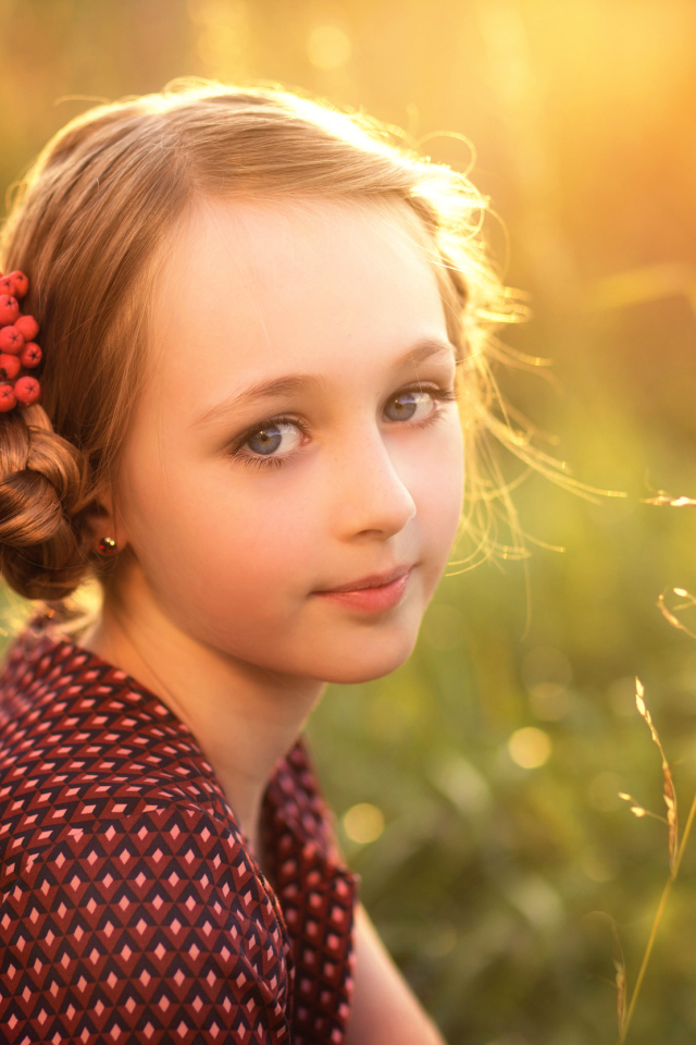 Красивая маленькая девочка с ягодами калины в волосах