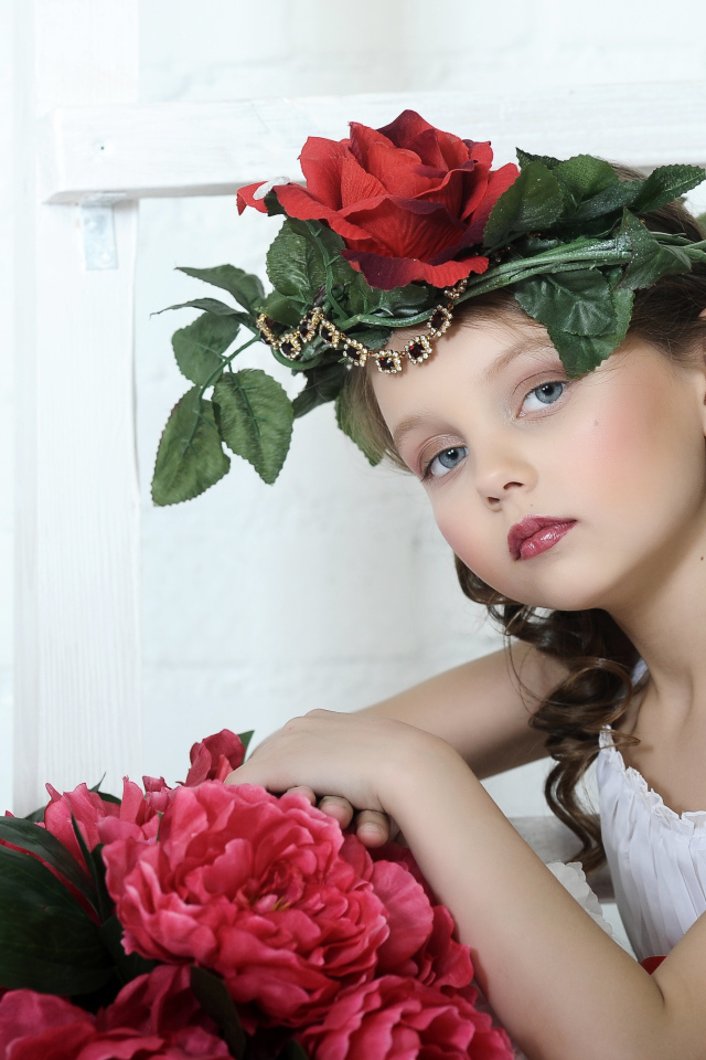 Красивая маленькая девочка с венком из роз на голове