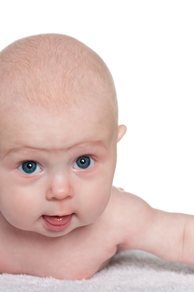 Голубоглазый малыш лежит на белом фоне