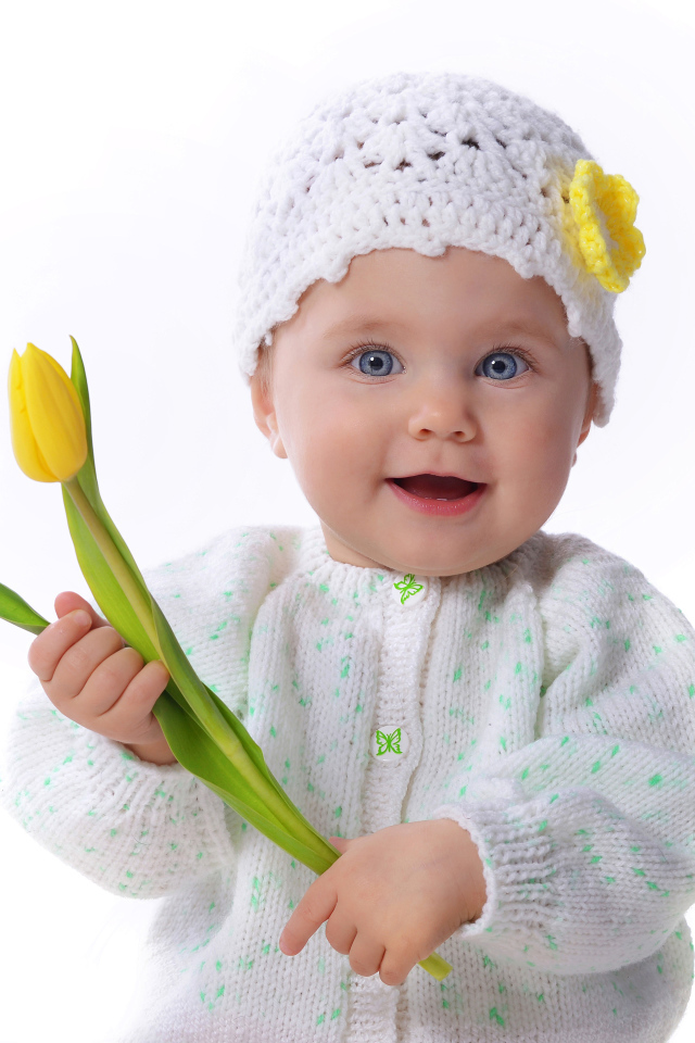 Голубоглазая маленькая девочка с желтым тюльпаном в руках