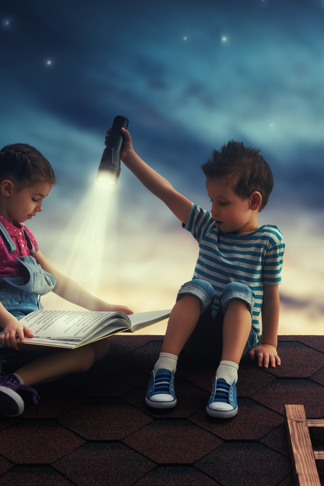 Мальчик и девочка ночью читают книгу на крыше