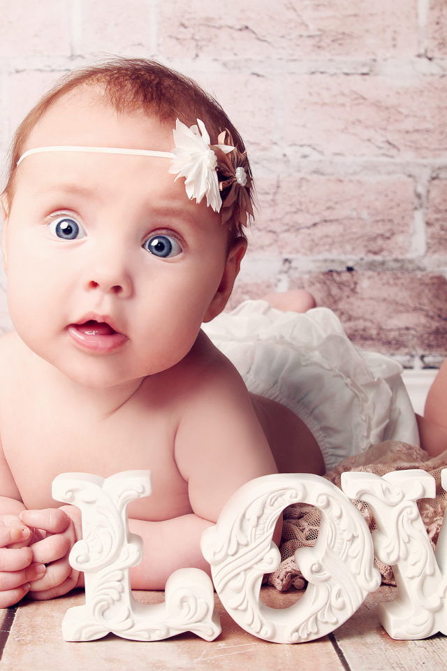 Грудной ребенок с надписью любовь на фоне кирпичной стены