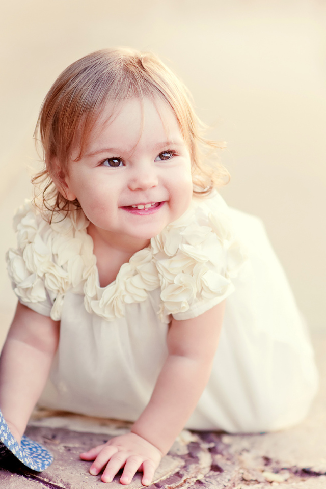 Милая улыбающаяся девочка в белом платье