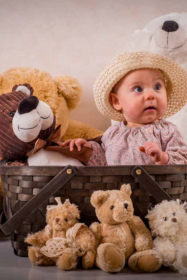 Забавный грудной ребенок в корзине с мягкими игрушками