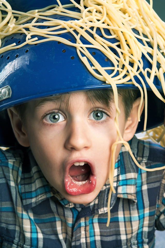Смешной мальчик со спагетти на голове