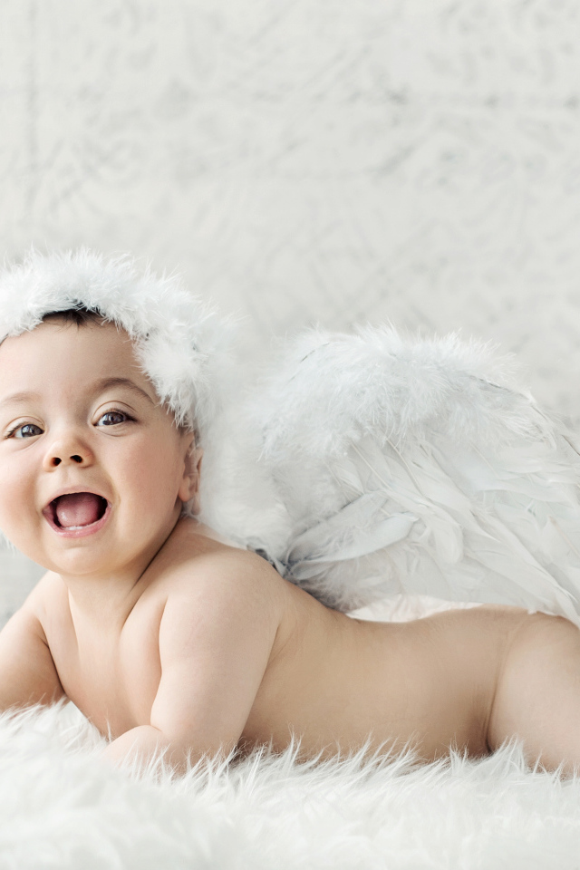 Забавный улыбающийся ребенок с крыльями ангела