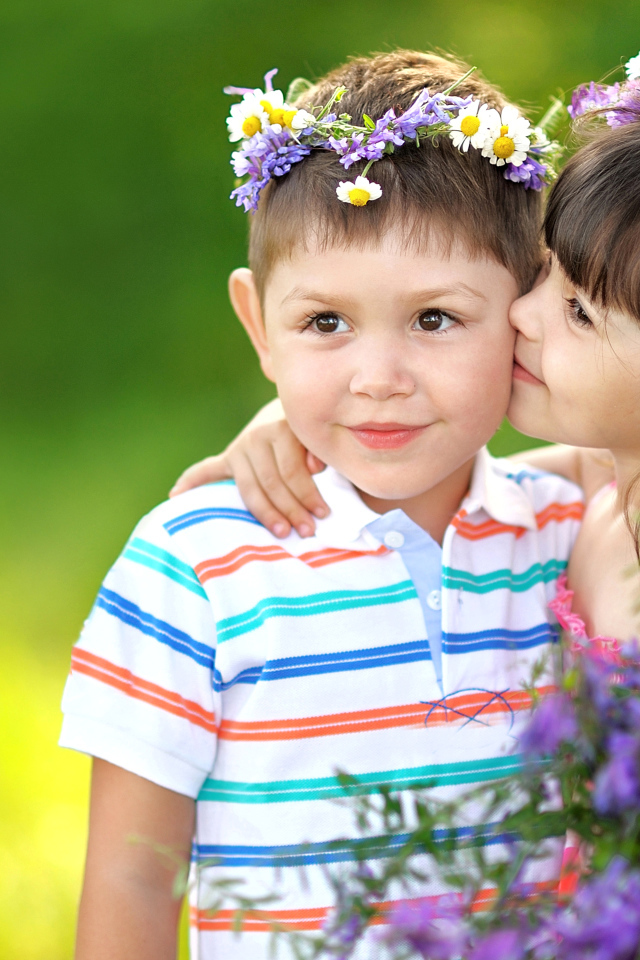 Маленькие мальчик и девочка с венками из полевых цветов на голове