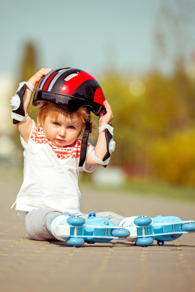 Маленький мальчик в шлеме и роликовых коньках