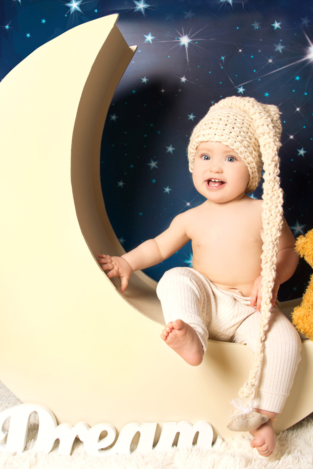 Маленький мальчик с плюшевым мишкой сидят на месяце