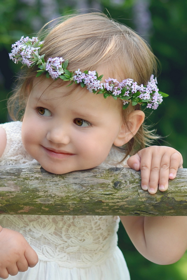 Маленькая кареглазая девочка с венком на голове