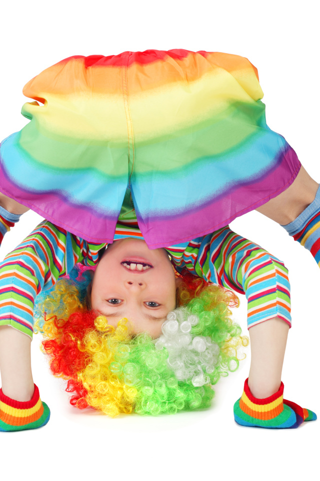 Маленькая смешная девочка в костюме клоуна на белом фоне