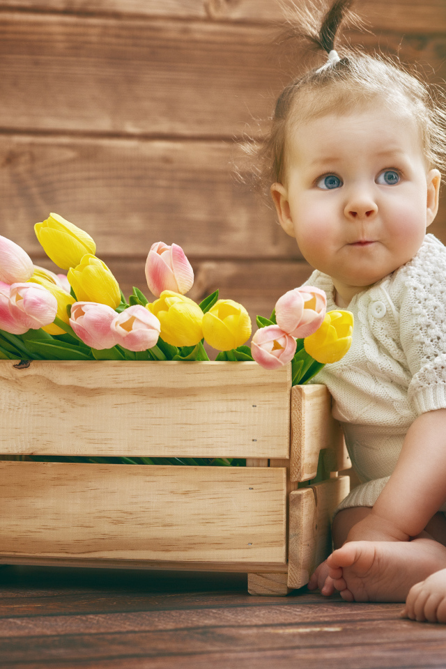 Маленькая забавная девочка с букетом тюльпанов