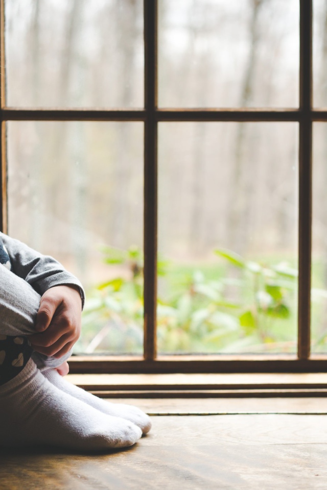 Маленькая девочка и цыпленок у окна 