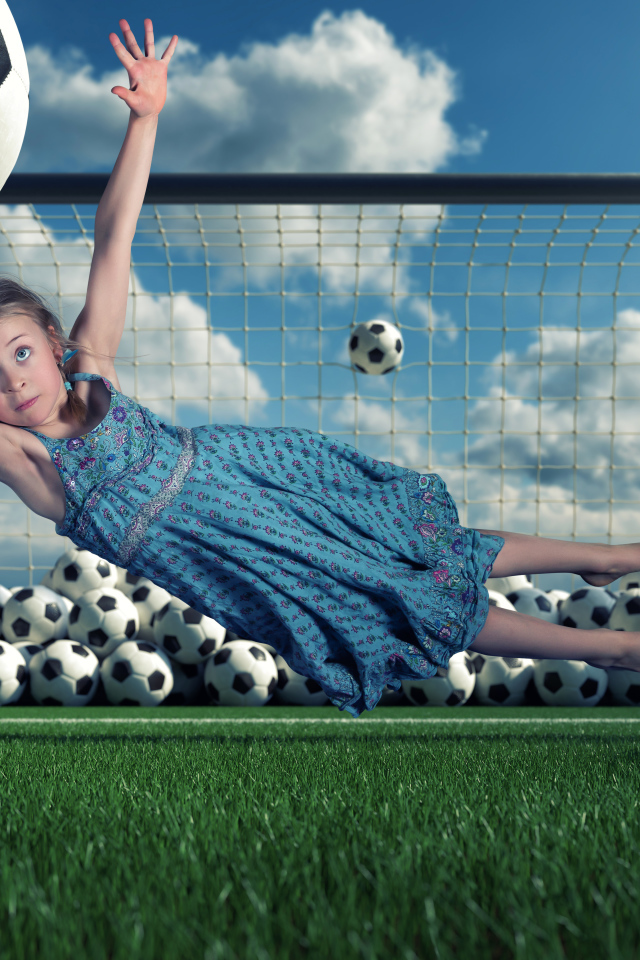 Маленькая девочка вратарь ловит мяч в воротах