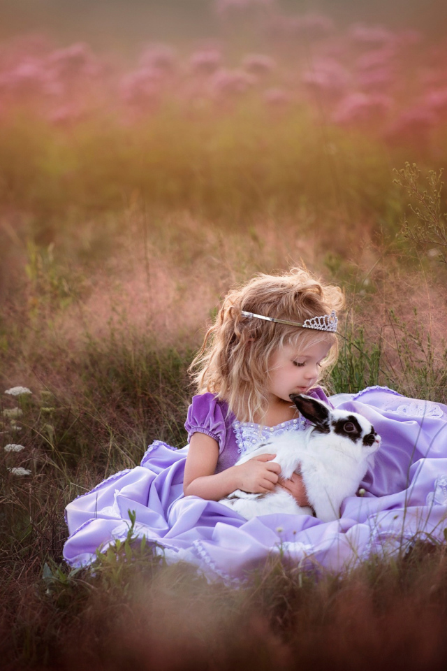 Маленькая девочка в красивом платье с кроликом в руках