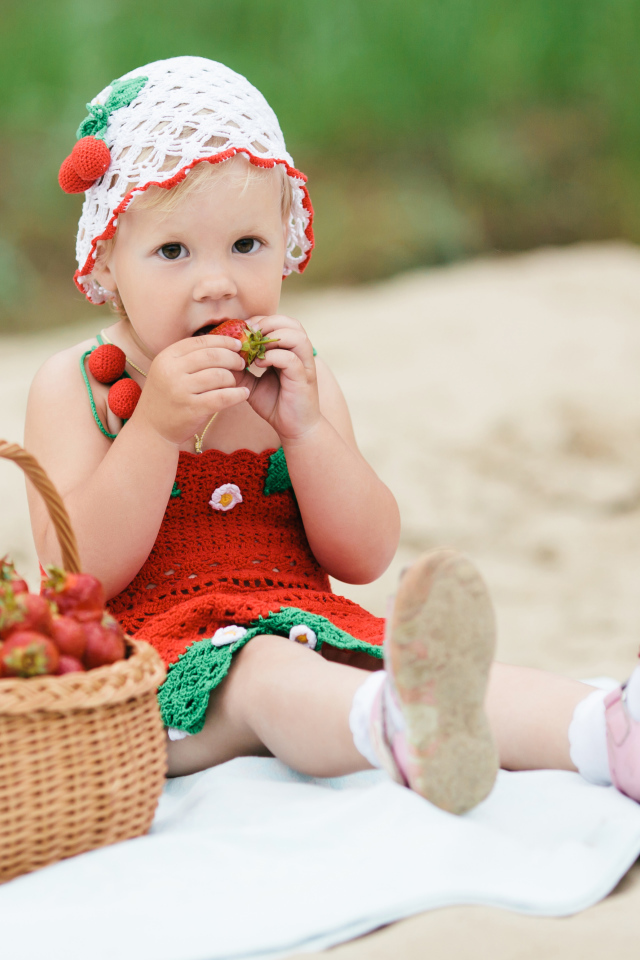 Маленькая девочка в большой корзиной клубники