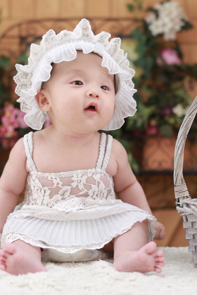 Маленькая девочка в белом платье с медвежонком в корзине