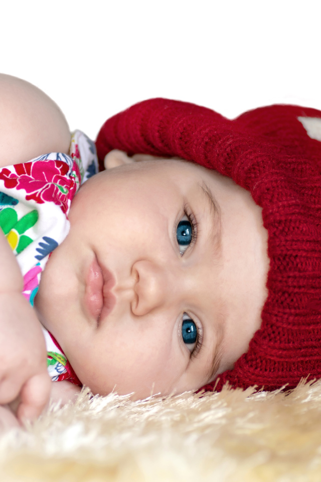 Маленькая девочка в красной вязаной шапке