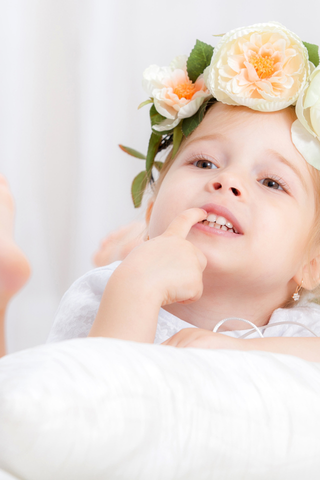 Маленькая девочка с красивым венком из цветов на голове