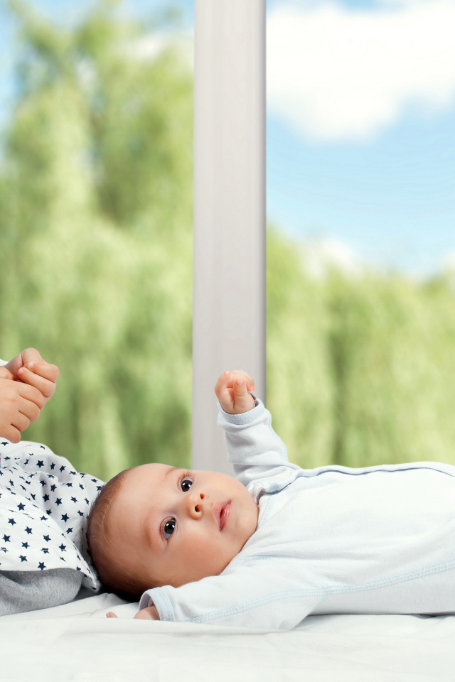 Маленькая улыбающаяся девочка с грудным ребенком