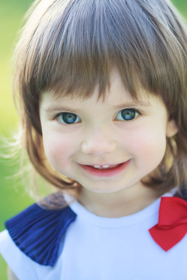 Милая улыбающаяся зеленоглазая маленькая девочка