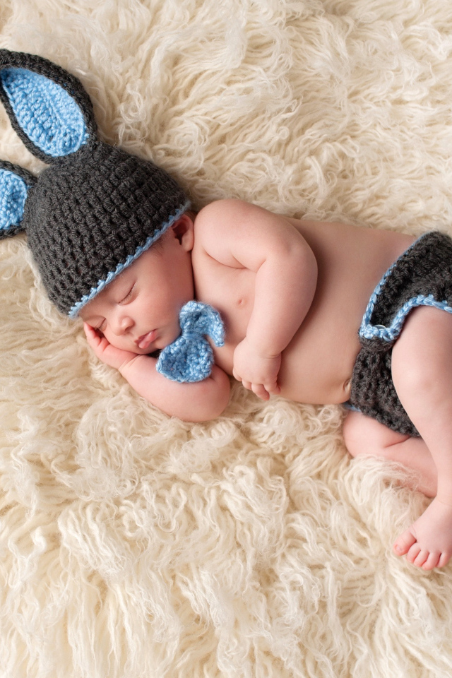 Спящий младенец в вязаном костюме зайца