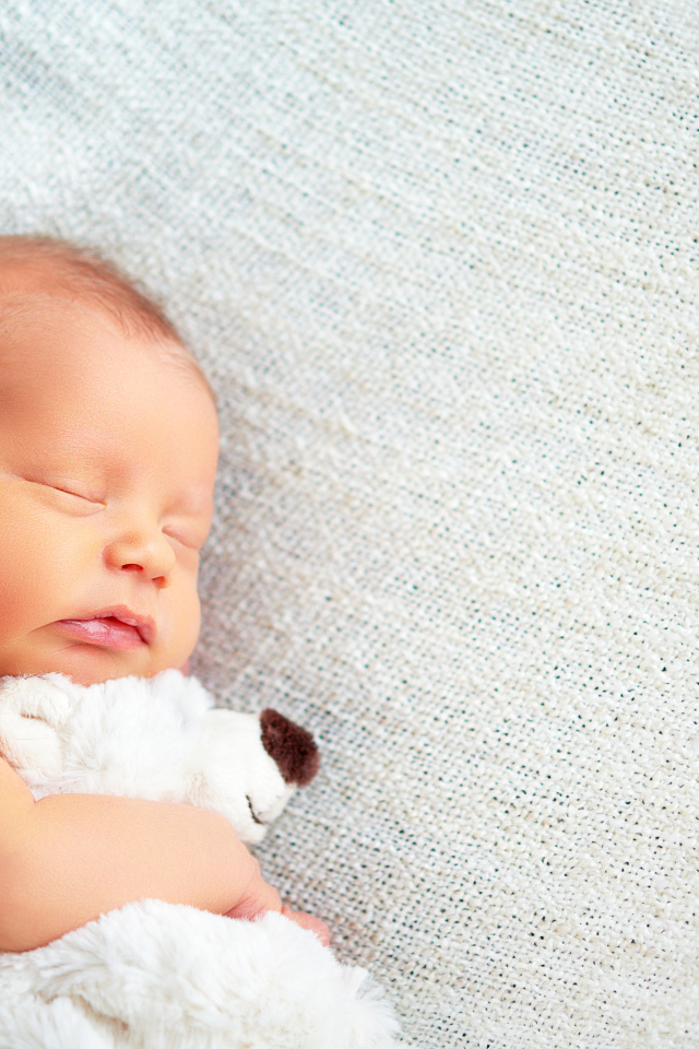 Спящий младенец с обнимает игрушку медведя