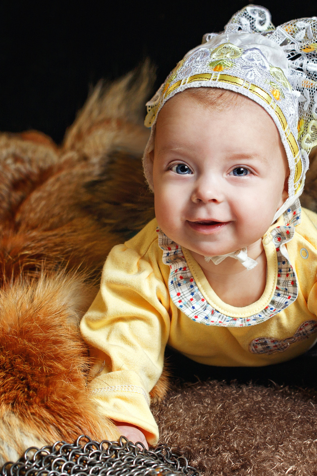 Улыбающаяся голубоглазая девочка в шапке