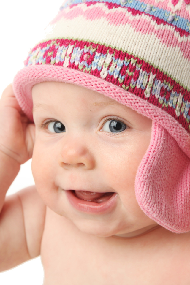 Улыбающийся ребенок в шапке на белом фоне