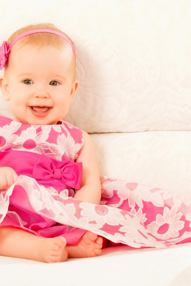 Улыбающаяся маленькая девочка в красивом розовом платье