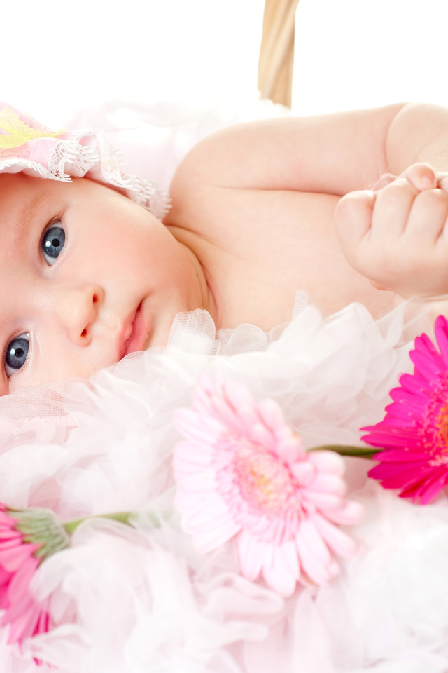 Милая девочка с шапке с тремя цветками герберы