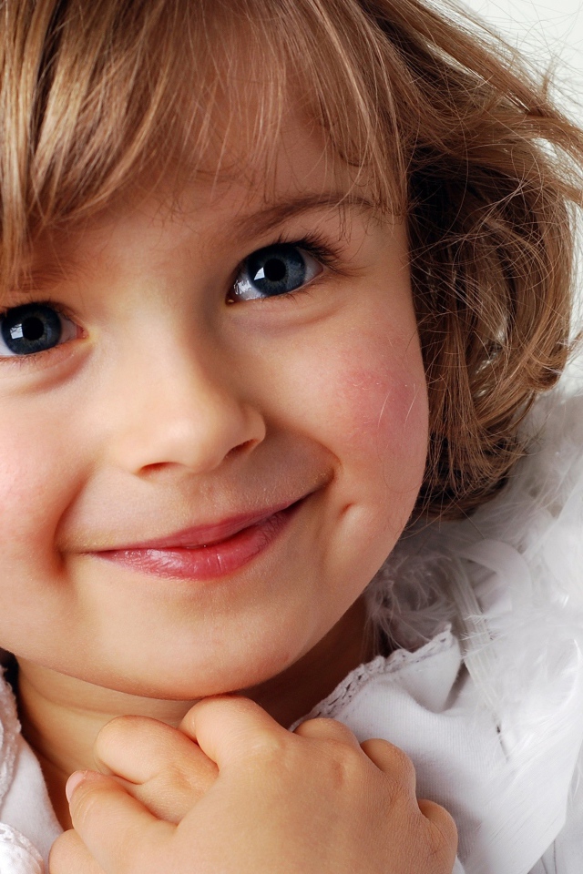 Маленькая голубоглазая девочка в костюме ангела 