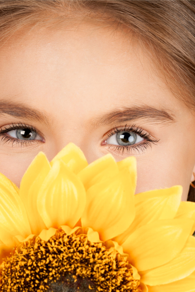 Взгляд маленькой девочки шатенки с подсолнухом в руках