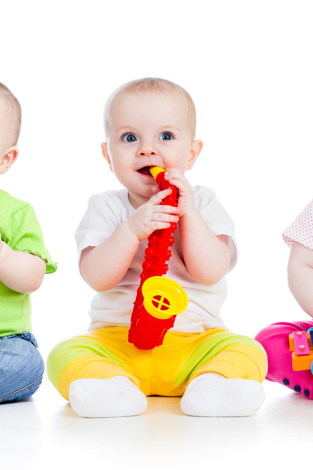 Три улыбающихся младенца играют на белом фоне