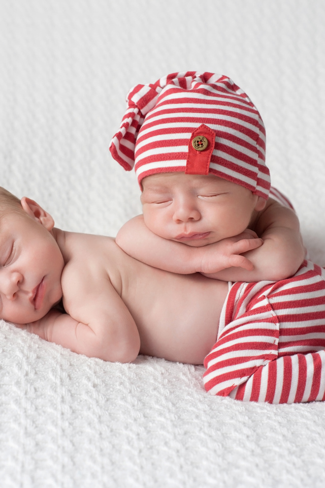 Два милых спящих младенца в полосатых костюмах