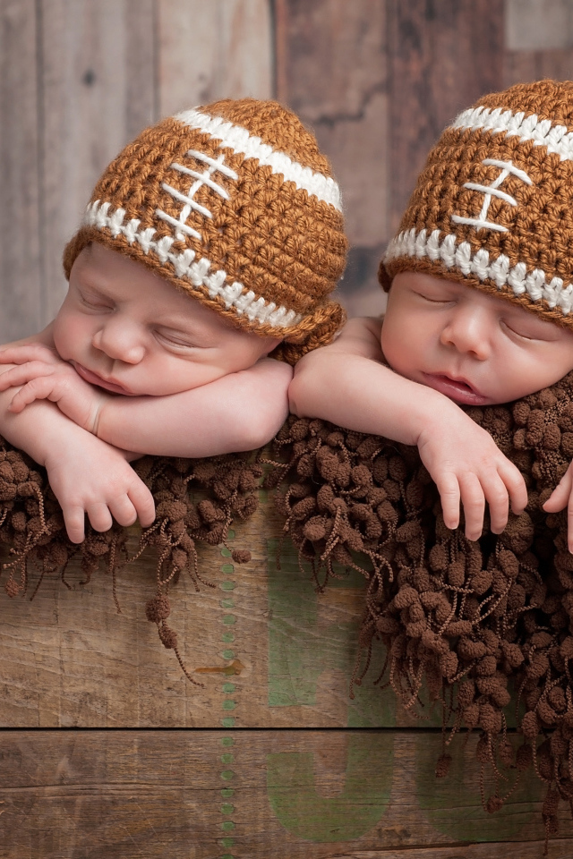 Два милых спящих малыша в забавных вязаных шапках