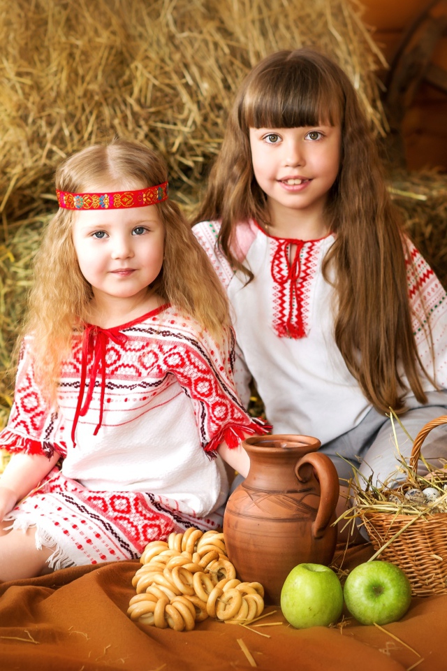 Две маленькие девочки в красивых костюмах с угощениями