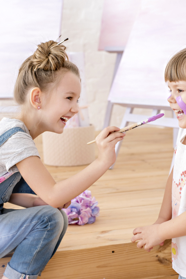 Две маленькие девочки играют с красками