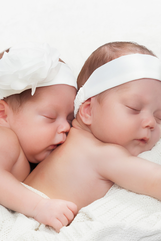 Два спящих младенца с большими белыми цветами на голове