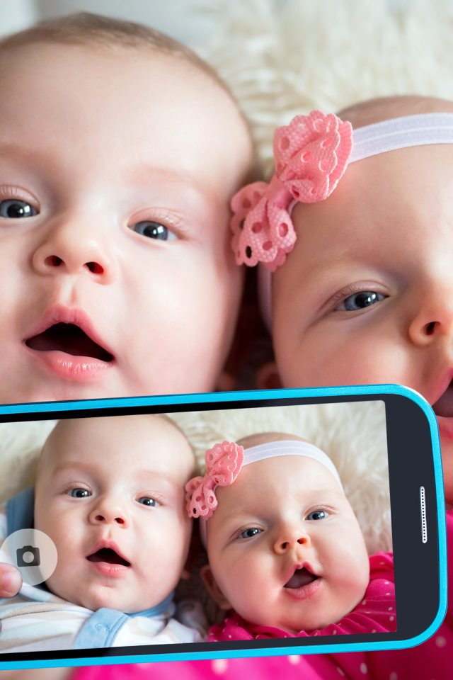 Два маленьких ребенка делают селфи на телефон