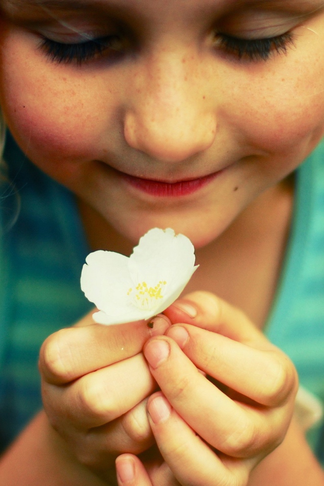 Маленькая девочка  держит белый цветок 