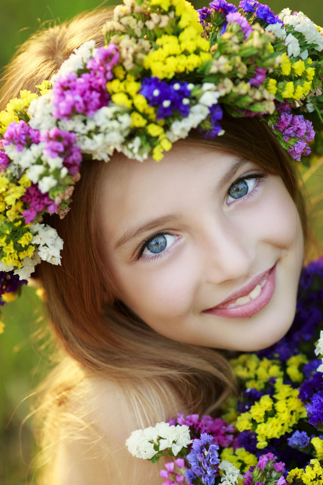 Маленькая голубоглазая девочка с полевыми цветами 